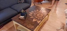 a dog standing next to a coffee table with a sunflower painted on it's side