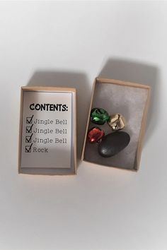 an open box with three rings in it and a note inside the box that says contents