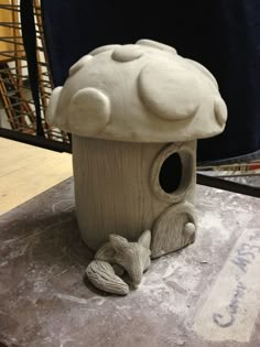 a clay birdhouse sitting on top of a table