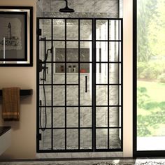 a glass shower door in a bathroom with tile flooring and black trim on the walls