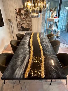 a black table with gold glitters on it in front of a chandelier