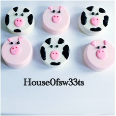 four cupcakes with pink and black frosting decorated as farm animals, on top of each other