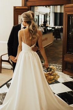 a bride and groom standing in front of a black and white checkered floor