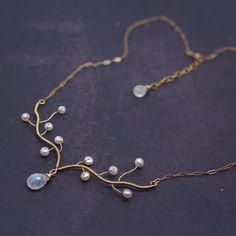 a gold necklace with white pearls on it