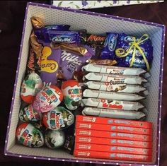 an open box filled with lots of different types of candies and chocolates on top of each other