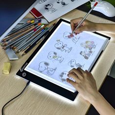 a person is drawing on a tablet with colored pencils