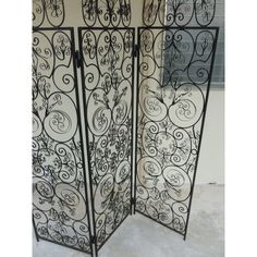 an ornate iron screen is shown in this room divider, which has been painted black