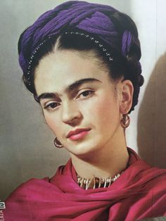 an old photo of a woman with purple hair and jewelry on her head, wearing a pink scarf