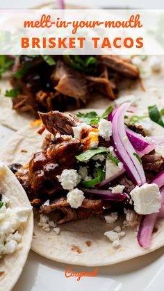 two tacos with meat, onions and feta cheese on them sitting on a plate