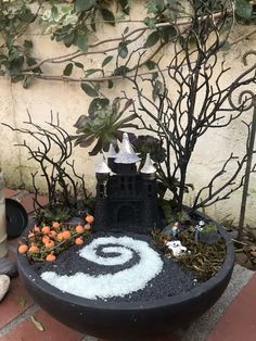 there is a black pot with white decorations on it and trees in the back ground