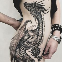 a woman's stomach with a dragon tattoo on her side and the bottom part of her body