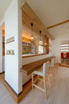 a kitchen with white walls and wooden flooring next to a counter top on the wall