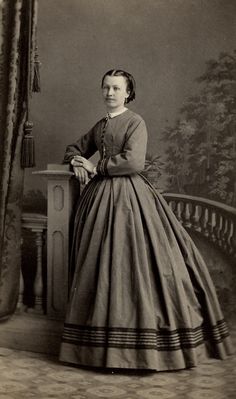 an old black and white photo of a woman in a dress