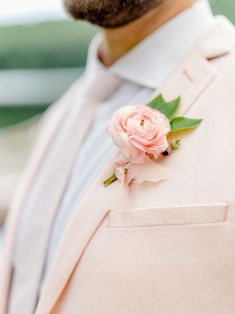 a man wearing a pink suit and flower boutonniere on his lapel