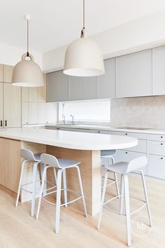 a kitchen with white counter tops and stools