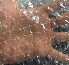 a person's arm wrapped in clear plastic with hearts on the wrist and hand