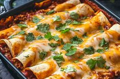 a casserole dish with meat, cheese and cilantro leaves on top