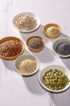 seven bowls filled with different types of seeds