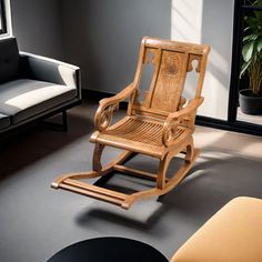 a wooden rocking chair sitting on top of a black floor next to a white couch