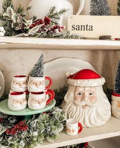 a shelf filled with christmas decorations and santa clause mugs on top of each other