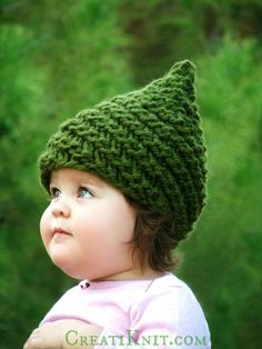 a small child wearing a green knitted hat