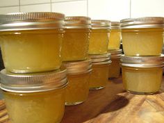 several jars filled with yellow liquid sitting on top of a wooden table