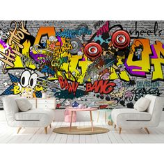 a living room with graffiti on the wall and two white chairs in front of it