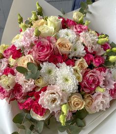 a bouquet of pink and white flowers sitting on top of a table