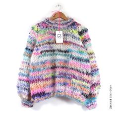 a colorful sweater hanging on a hanger with a tag that says,'i love you