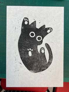 a black and white drawing of a cat with paw prints on it's back