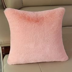 a pink pillow sitting on top of a couch