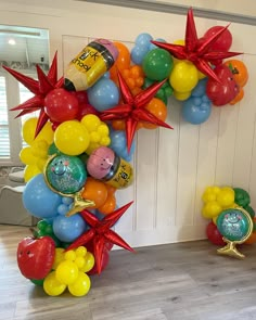 a balloon arch is decorated with balloons and starbursts