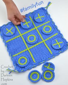 a crocheted blue and yellow board game with numbers on it is being held by someone's hand