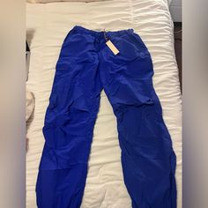 Blue Cargo Parachute Pants New With Tags Blue Athleisure Sweatpants For Spring, Spring Blue Athleisure Sweatpants, Blue Stretch Nylon Bottoms, Spring Blue Joggers With Elastic Waistband, Spring Stretch Blue Joggers, Blue Stretch Joggers For Spring, Blue Cargo Pants With Elastic Waistband For Spring, High-waisted Blue Cargo Pants With Elastic Waistband, Blue Cargo Pants With Elastic Waistband And Tapered Leg