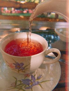 tea being poured into a cup on a saucer