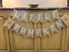 a little pumpkin banner hanging from the side of a kitchen counter top next to a wooden cabinet