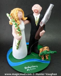 a wedding cake topper with a bride and groom holding an umbrella next to a turtle