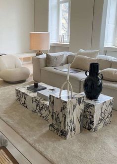 a living room filled with furniture and a large mirror on the wall above it's coffee table