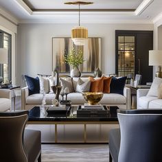 a living room filled with furniture and a chandelier hanging from the ceiling over a coffee table