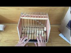 someone is typing on a computer keyboard with many wooden sticks attached to the keyboard and hands