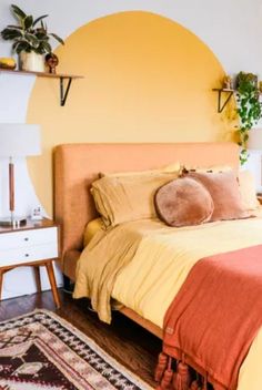 a bed with yellow sheets and pillows in a bedroom next to a wall mounted planter