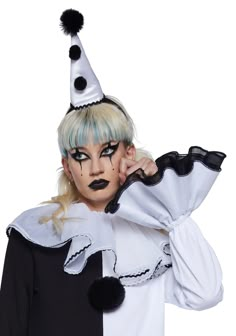 a woman with blue hair and black makeup wearing a clown costume is posing for the camera