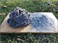 two different colored rocks sitting on top of a wooden board