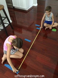 two children are playing with tape on the floor