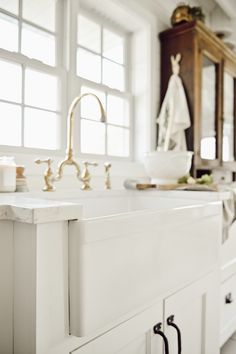 a white kitchen sink sitting under a window