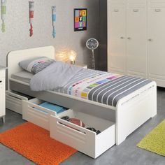 a child's bedroom with white furniture and colorful rugs