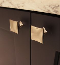 two square knobs are attached to the cabinet doors