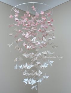 a wind chime with pink and white butterflies hanging from it's centerpiece