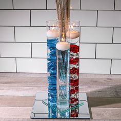 two tall glass vases with candles in them