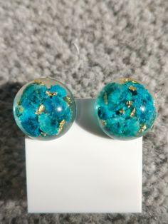 These stunning earrings are made with blue baby Breaths together with gold leaf, setting in crystal clear resin. They are 100% hand made by me🌸 Perfect Gift for Any occasion. Handmade Blue Round Clip-on Earrings, Blue Resin Jewelry For Party, Blue Resin Jewelry For Parties, Handmade Turquoise Resin Earrings, Clear Hypoallergenic Resin Earrings, Hypoallergenic Clear Resin Earrings, Blue Round Plug Earrings As Gift, Blue Round Plug Earrings For Gift, Gold Round Resin Earrings